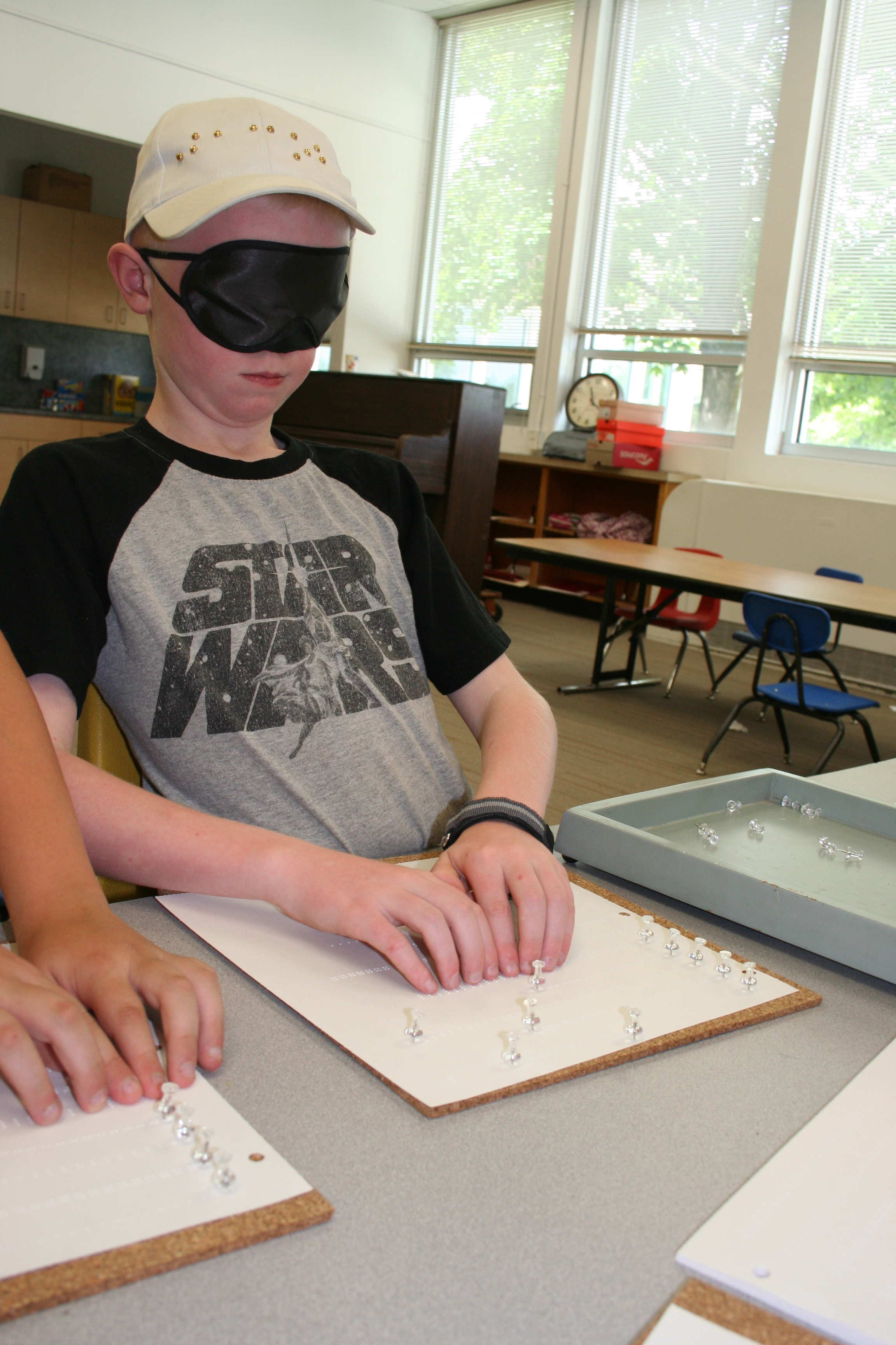 Jacob Sorenson works on his Braille reading under sleep shades.